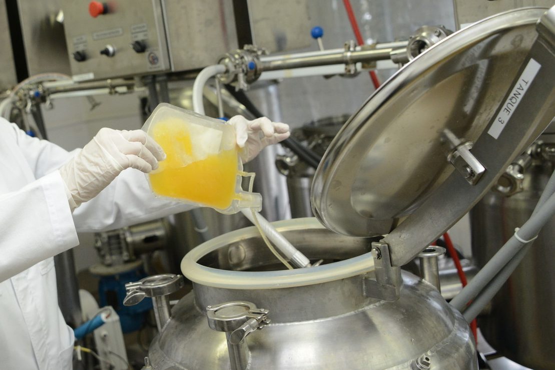 Plasma purification A production worker pours yellow plasma into a large stainless steel container.